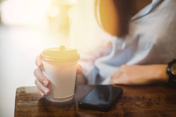 istock Hot drink in paper cup in hands close up 938456462