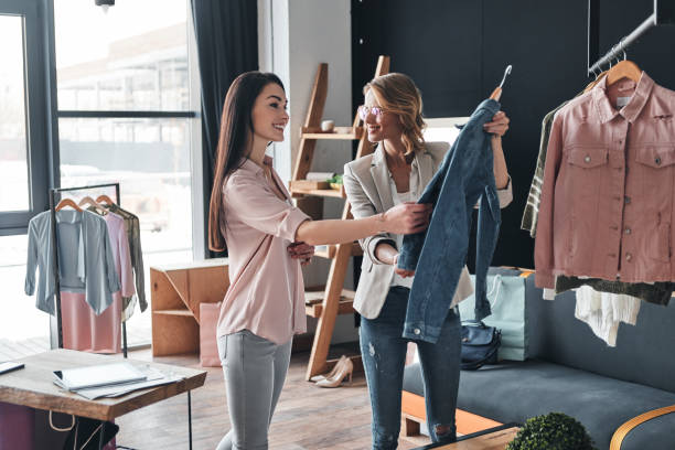 was denken sie über diese? - women choosing choice clothing stock-fotos und bilder