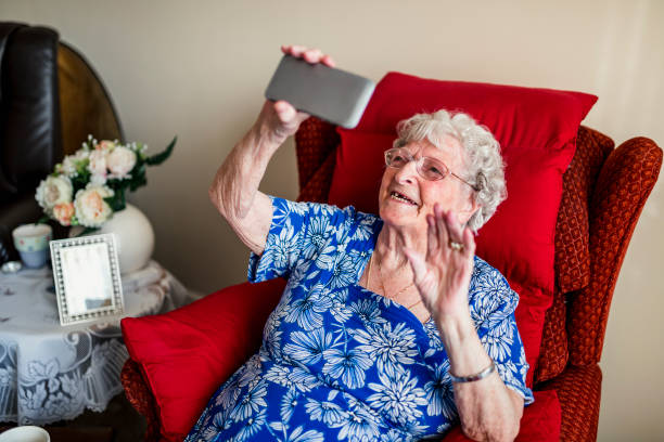 mujer mayor con un teléfono m�óvil - help palabra en inglés fotografías e imágenes de stock