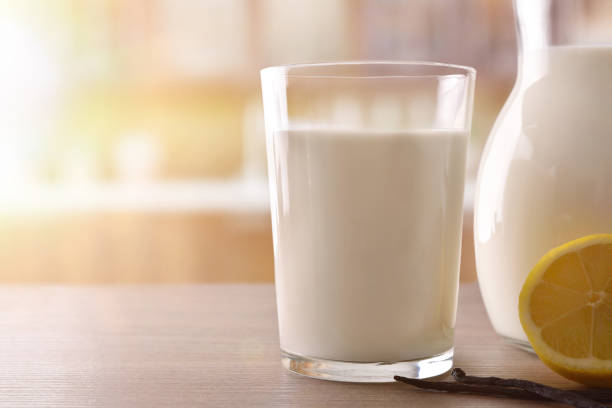 istock Glass of milk on wooden table lemon and cinnamon front 938464876