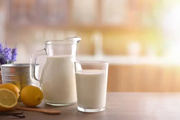 Photo of Glass of milk on wooden bench in a rustic kitchen