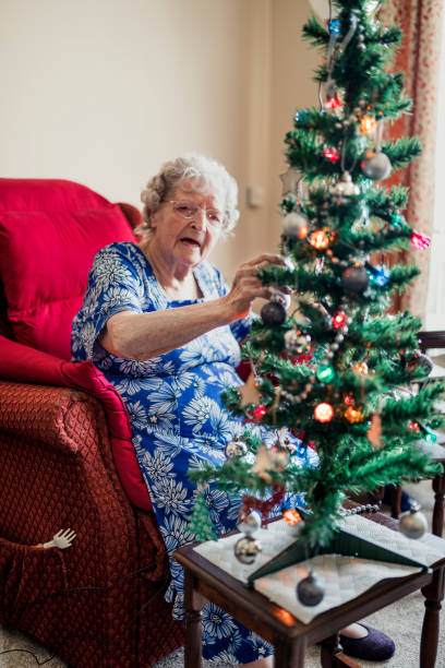 istock Elderly Woman Decorating a Christmas Tree 938465042