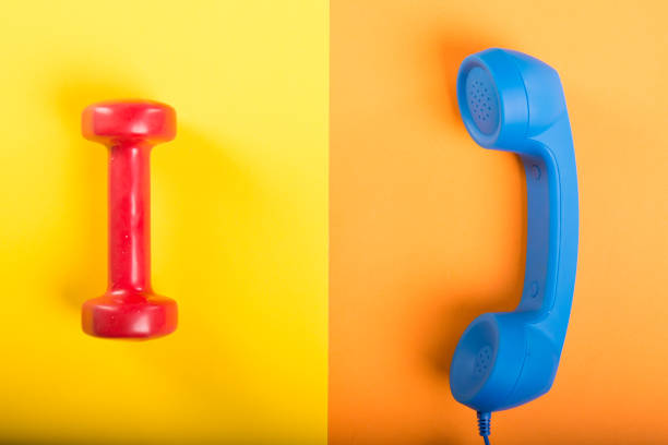 istock Telephone receiver and one dumbbell 938475832