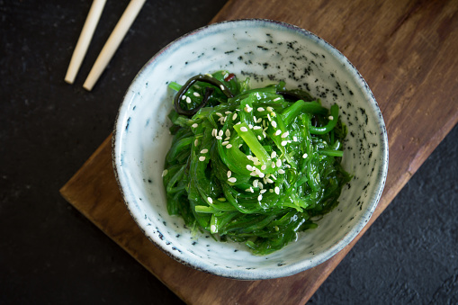 Chuka Seaweed Salad in ceramic bowl over black background, copy space. Japanese Cuisine - Chuka Salad