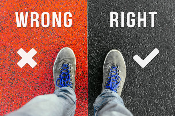 istock Concept of facing a crucial decision about wrong and right shown by shoes on different colored pathways 938476590