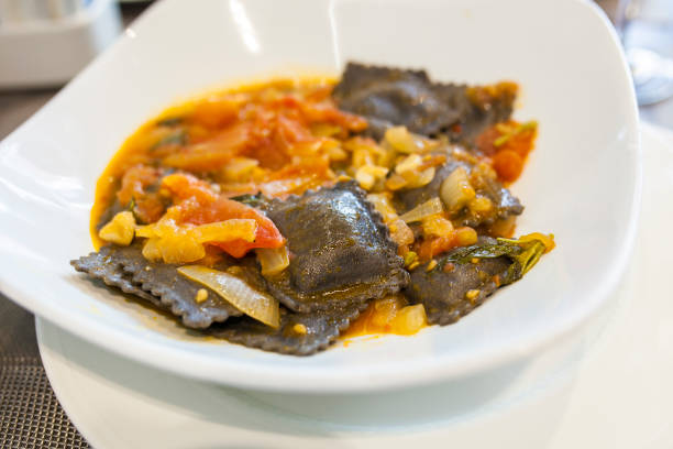 istock Black squid ink ravioli with natural tomatoes sauce 938480762