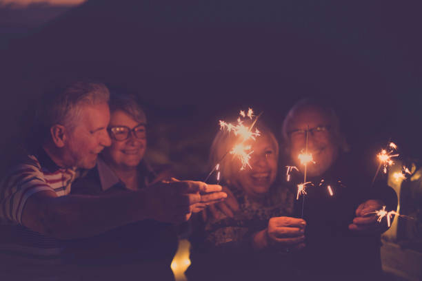 istock four aged people having party by night 938481282