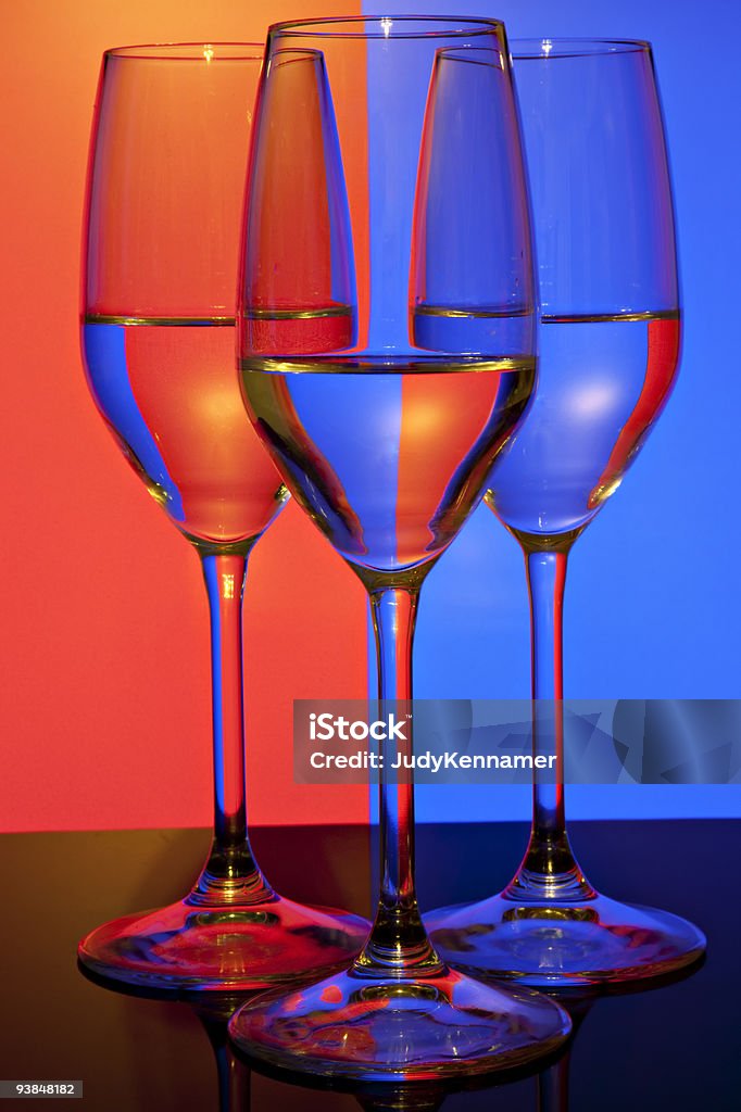 Três copos de vinho na frente de laranja e azul fundo - Foto de stock de Abstrato royalty-free