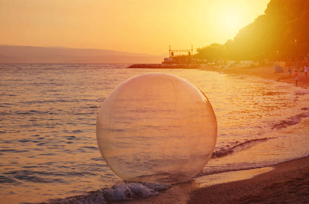 water ball on the sunset beach at summer water ball on the sunset beach at summer, toned zorb ball stock pictures, royalty-free photos & images