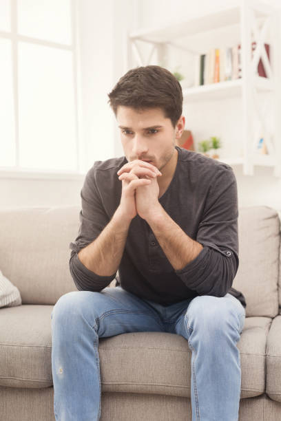 istock Pensive young man at home 938486142
