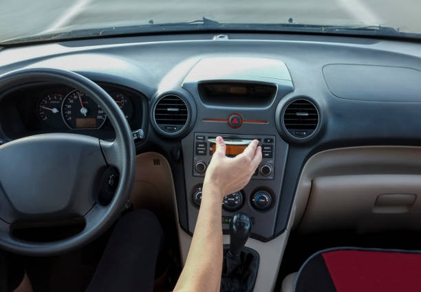 Woman inserting CD Audio while she is driving. Cause of Distracted Driving Accidents concept Woman inserting CD Audio while she is driving. Cause of Distracted Driving Accidents concept. Inside car view home cinema system stock pictures, royalty-free photos & images