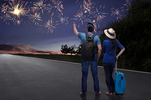 Happy asian couple tourist watching beautiful fireworks at outdoor