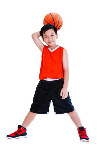 Full length of young asian basketball player in sportswear standing and posing with a ball in his hand. Handsome boy smiling and looking at camera. Studio shot. Isolated on white background.