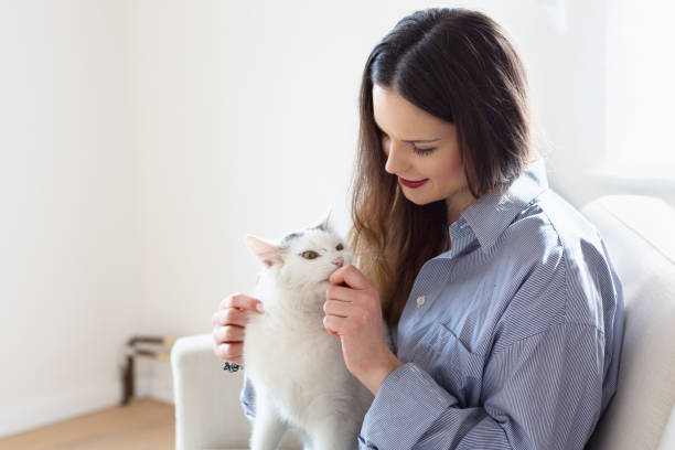 istock young woman playing with cat 938494760