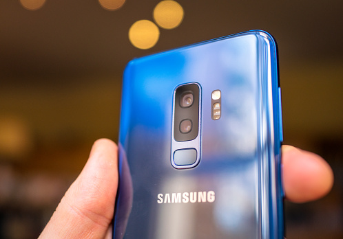 Edinburgh, UK - Close-up of the back of a coral blue coloured Samsung Galaxy S9+ smartphone, showing the dual camera lenses. The phone's variable aperature lens technology is a key new feature of the model.