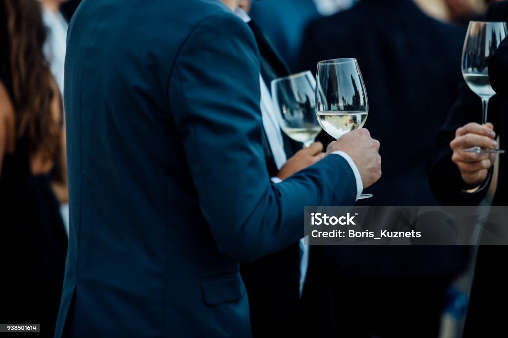 Couple of man  with a glass of wine at social event wearing elegant cloth. Business Stock Photo