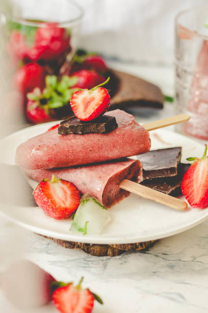 Strawberry ice cream with chocolate popsicles. Raw dessert. Mint. Detox diet and summer food concept. stock photo