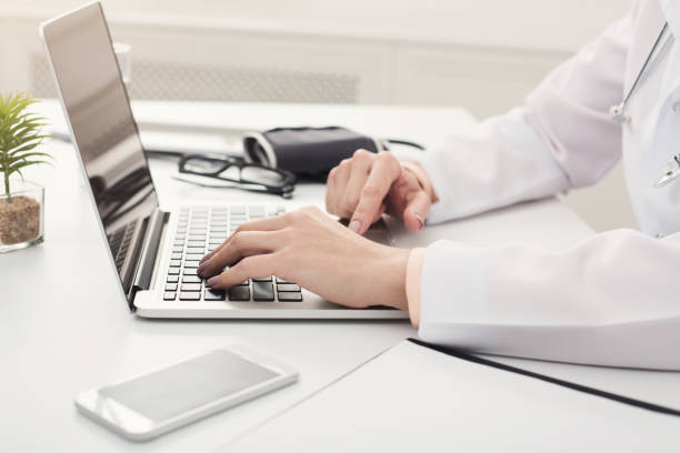 istock Doctor hands typing on laptop closeup 938503758