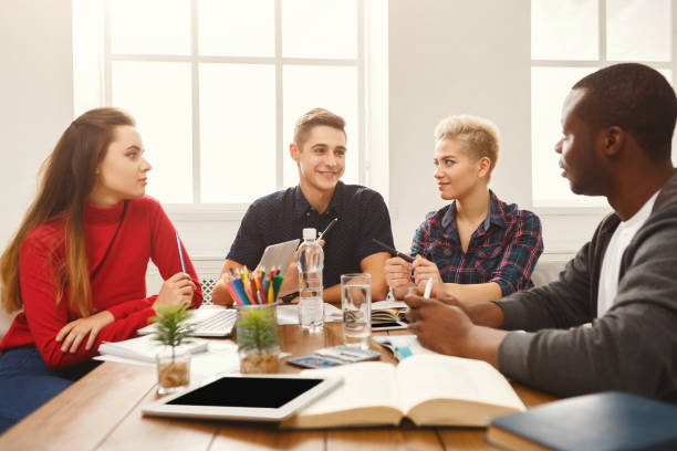 istock Group of diverse students studying at wooden table 938505850
