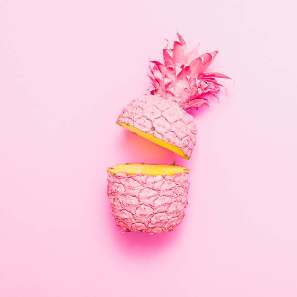 istock two painted in pink color halfs of the pineapple. 938506476