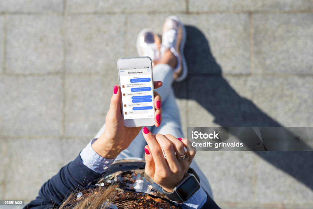 Woman using instant messaging app on mobile phone Woman using instant messaging app on mobile phone, view from above Online Messaging Stock Photo