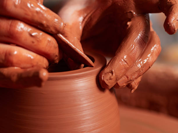 istock production process of pottery. Forming a clay teapot on a potter's wheel. 938515816