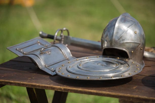 istock Helmets, Shields and Medieval Metallic Armors and Weapons, Outdoors on Wooden Table 938515828