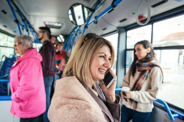 istock Cheerful business person using phone in public bus 938523912