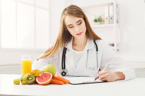 istock Nutritionist desk with fruit and measuring tape 938524508