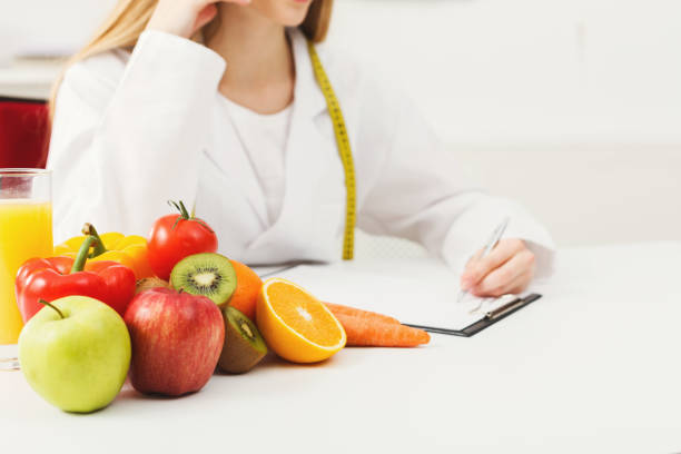 istock Nutritionist desk with fruit and measuring tape 938524582