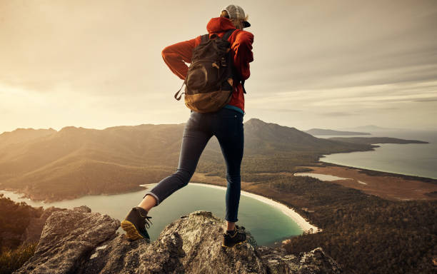 Rearview shot of a young woman hiking through the mountains