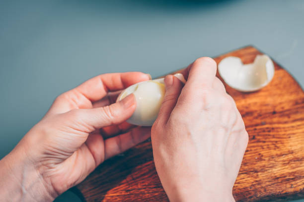 istock A woman cleans a boiled egg from the shell, a first-person view 938528536