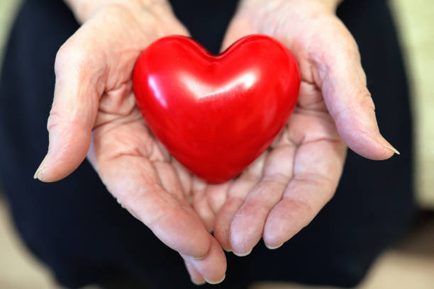 istock elder woman holding heart 938535834