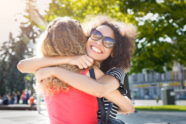 istock Happy girls hugging while walking in the city 938536522