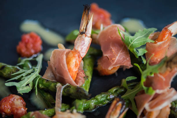 istock Shrimp and jamon dish with herbs and sauce on a black background. Served starter meals 938537062