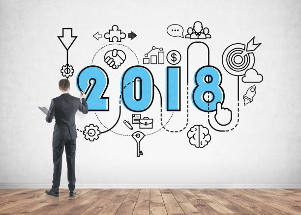 istock Businessman drawing 2018 business plan on wall 938537200