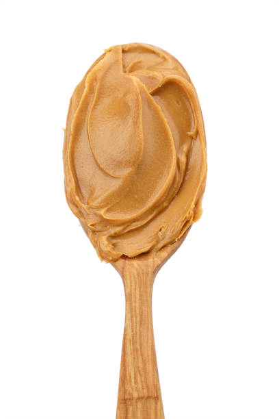 istock spoon with natural organic peanut butter, on white background 938546496