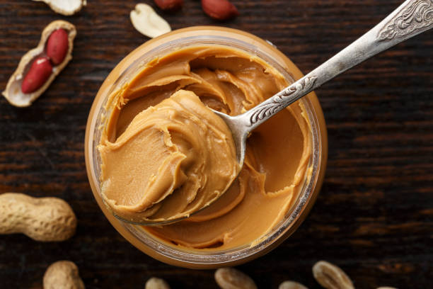 istock peanut butter in an open jar on a brown wooden background 938546518