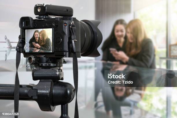 Professional Digital Mirrorless Camera With Microphone Recording Video Blog Of Two Asian Young Businesswoman Using The Smart Phone Camera For Photographer Or Video And Live Streaming Concept Stock Photo - Download Image Now