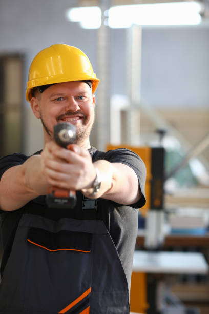 istock Arms of worker using electric drill closeup 938547386