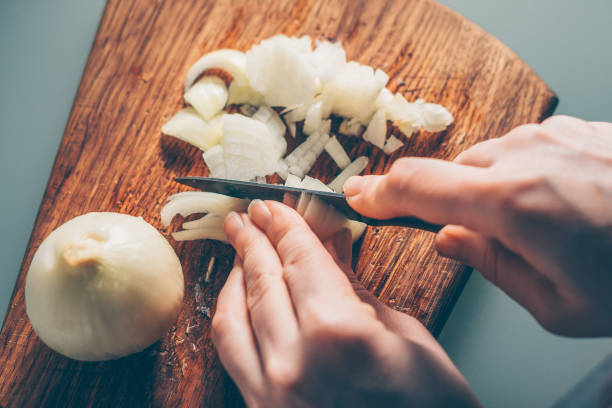 The cook cuts the onion on a cutting board