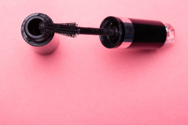 istock Eyelash makeup brush and mascara bottle close up on pink background with copyspace 938556062
