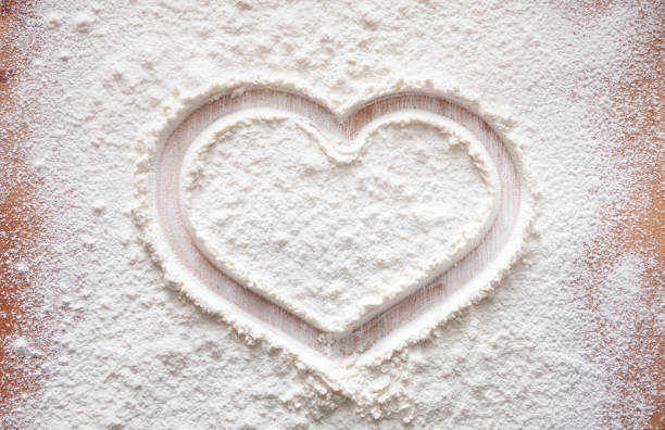 istock Baking concept on wood background, sprinkled flour with heart, copy space 938559130
