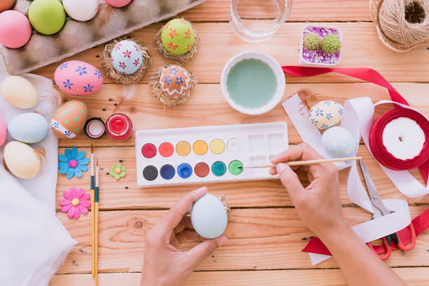 istock Happy easter! A woman hand painting Easter eggs. Happy family preparing for Easter. 938569536