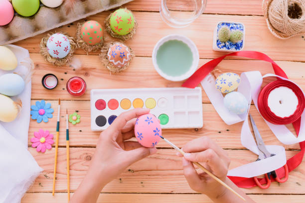 istock Happy easter! A woman hand painting Easter eggs. Happy family preparing for Easter. 938569612
