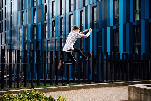 Freerunner is jumping between walls in the city.