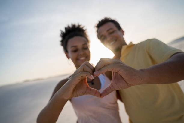 istock Happy couple making a heart shape at the desert 938577854