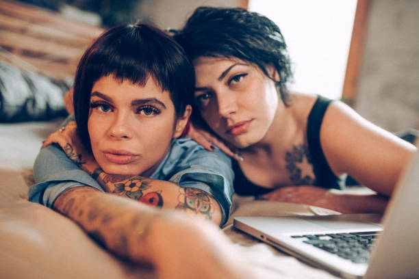 istock Lesbian couple laying on bed and using laptop 938586758