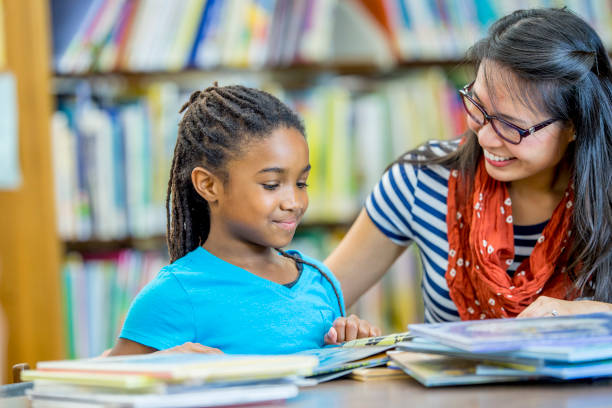 istock Girl In Library With Librarian 938588236