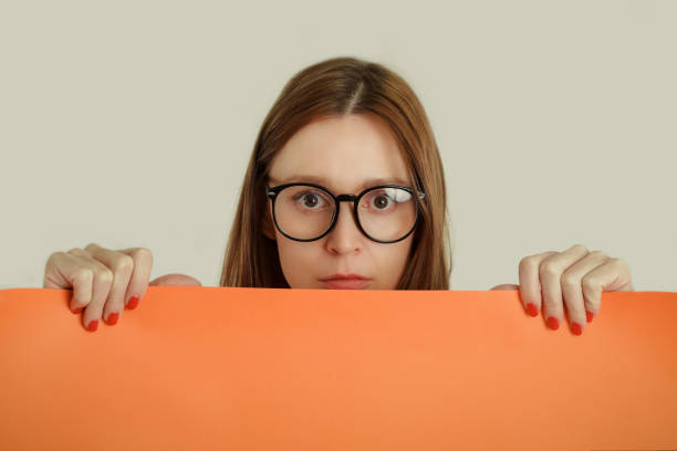 istock Woman holding blank orange paper 938617072